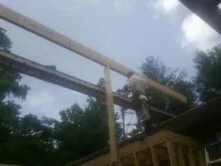 Carpenter setting a ridge beam over a new addition frame — Ice Dam Removal by Roofing Brothers in Darby