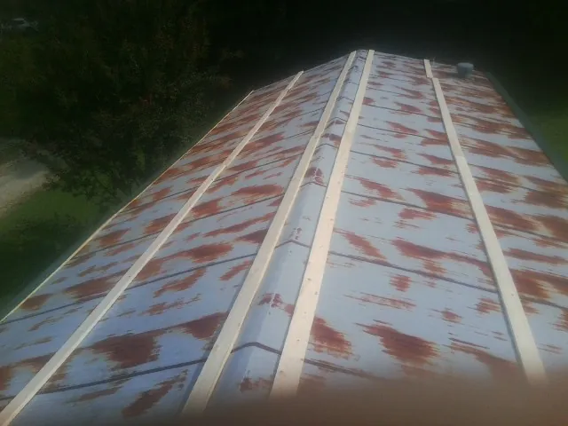 Rusted metal roof panels with new wood purlins before replacement — Storm Damage Roof Repair in Darby by Roofing Brothers