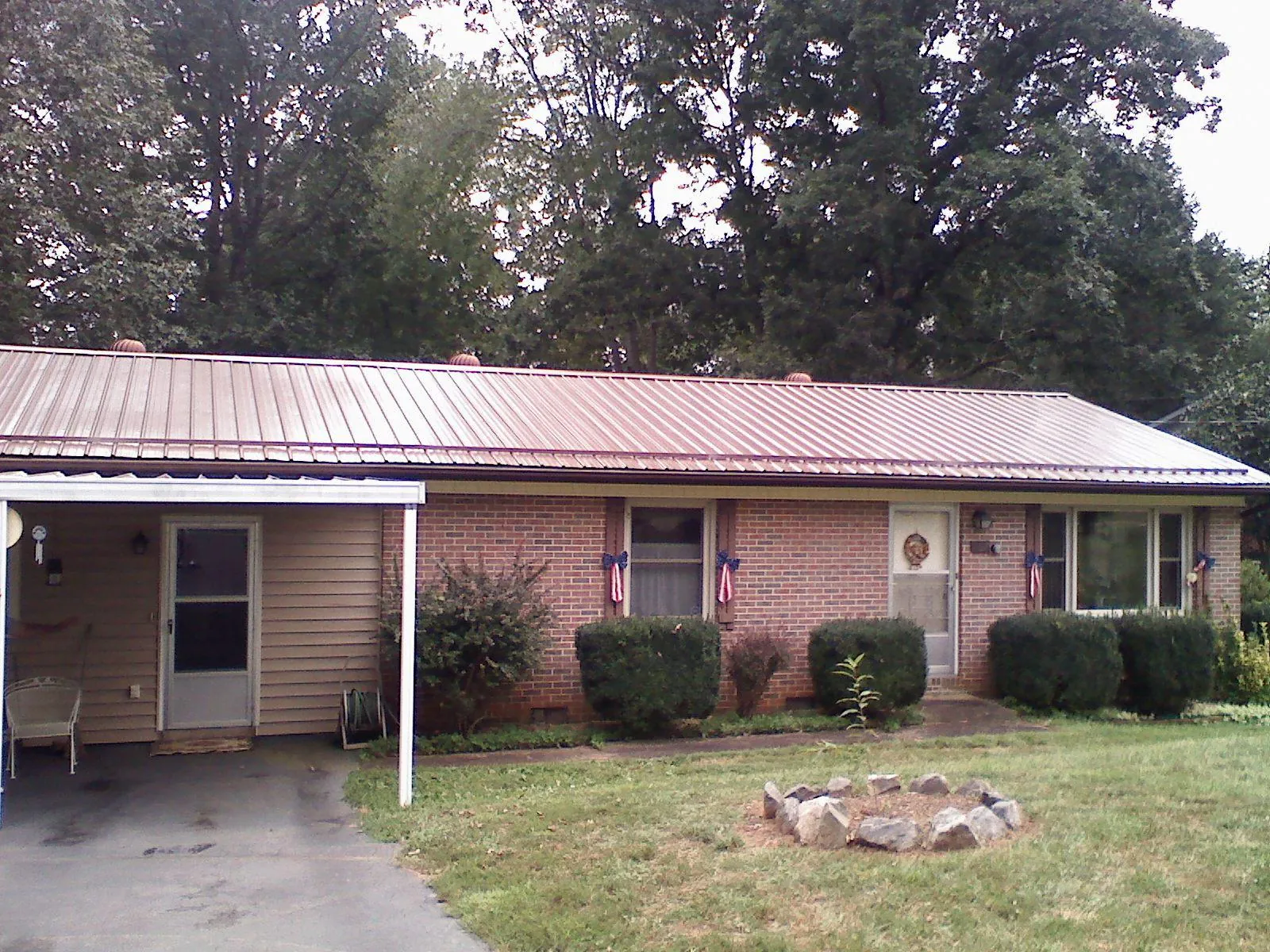 Bronze metal roof and carport on a brick ranch home — Roof Repair work by our crew in Darby
